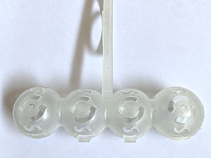 Providan brizgani plastični deo sa četiri kupole i ulivnim kanalom, na beloj podlozi.