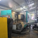 CNC glodalica DMU 80 P sa otvorenim radnim prostorom i okruglim stolom; operater u majici M-TOOLS radi pored mašine, desno je upravljački pult.