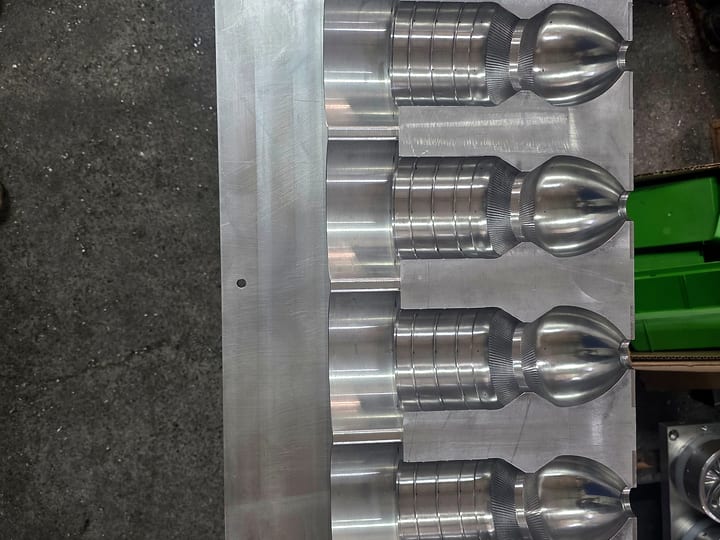 Aluminijumska ploča kalupa za duvanje sa četiri gnezda za boce sa nazubljenim ramenom.
