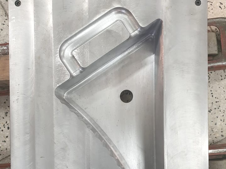 Aluminijumska polovina kalupa sa gnezdom za trouglastu posudu sa drškom.