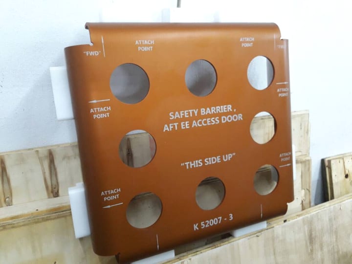 Narandžasti limeni panel sa otvorima i natpisom SAFETY BARRIER, AFT EE ACCESS DOOR, K 52007-3.
