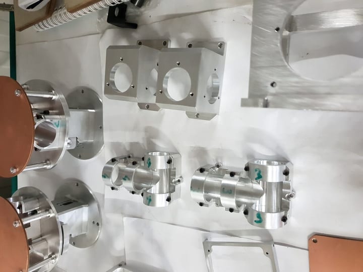 Više glodanih aluminijumskih kućišta i blokova sa otvorima, na beloj podlozi (2018).